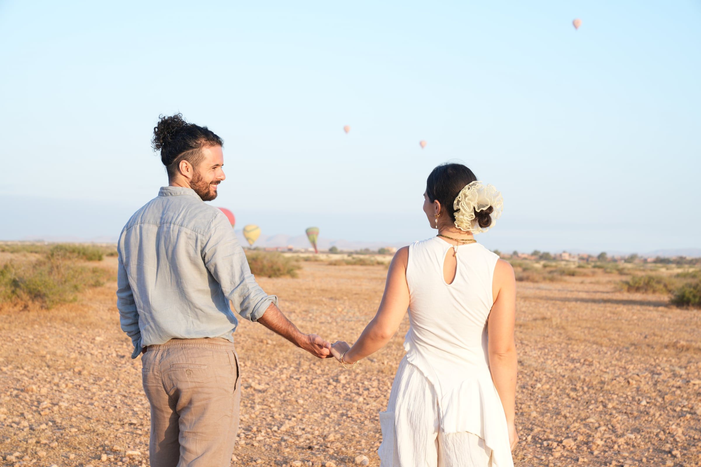 Couple walking hand in hand in the Agafay desert near Marrakech