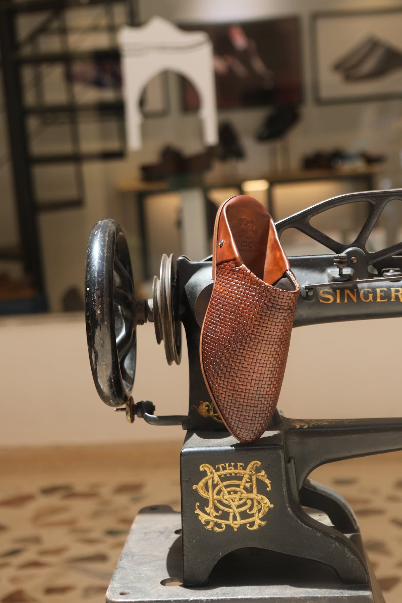Handmade leather shoe on a vintage sewing machine