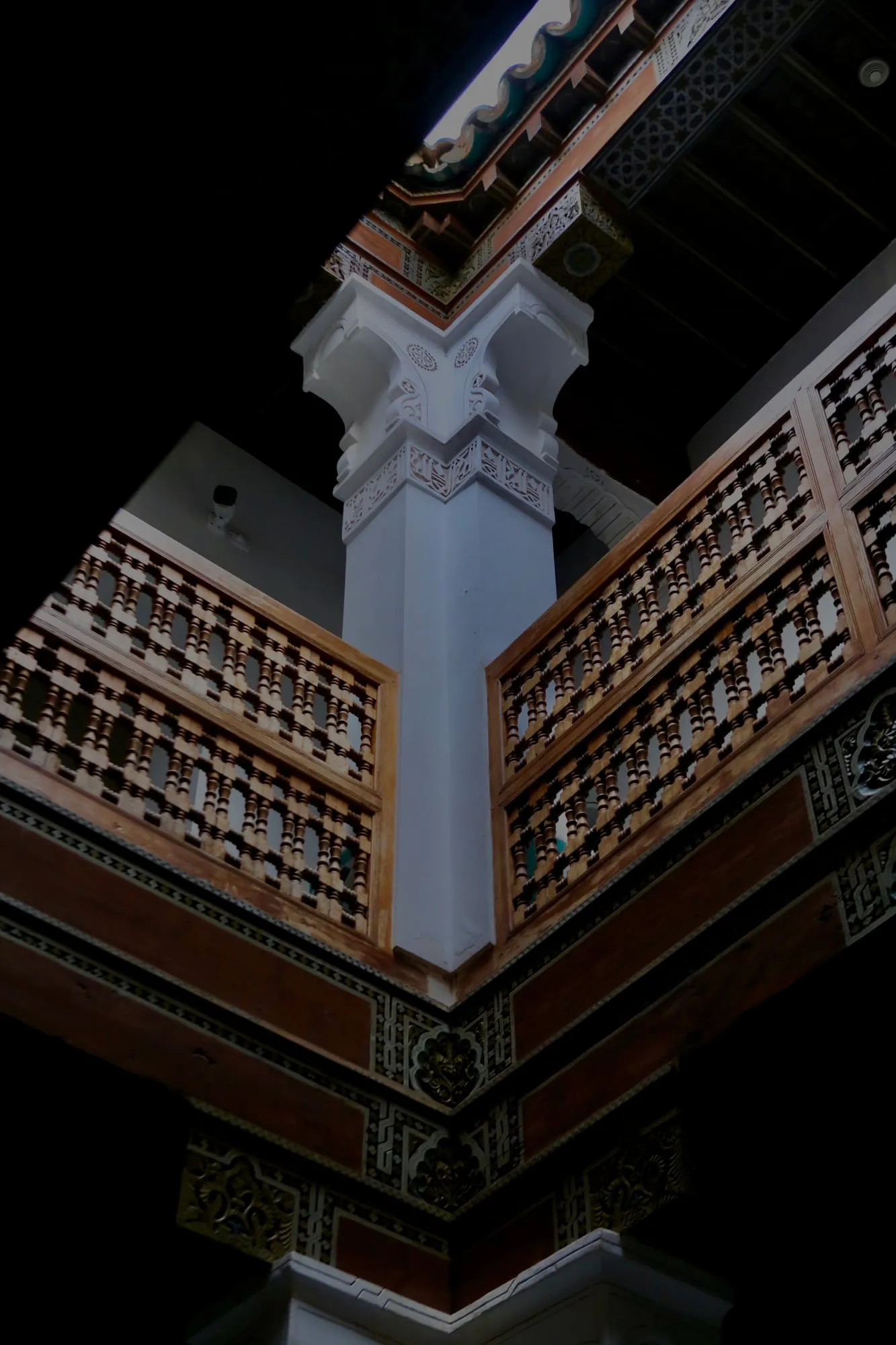 Carved wooden galleries of a riad atrium seen from below