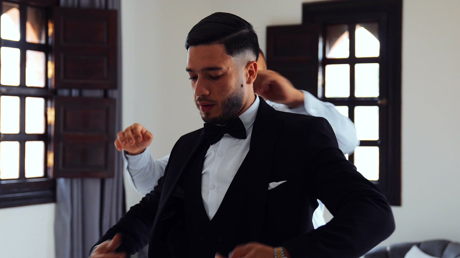 Groom adjusting his tuxedo before the ceremony